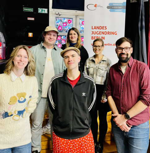 Freundliches Gruppenfoto des Landesjugendring-Vorstands vor einem Banner