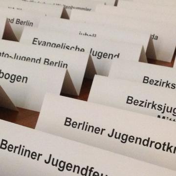 Nahaufnahme von 34 vorbereiteten Tischkärtchen mit den Namen von Berliner Jugendverbänden