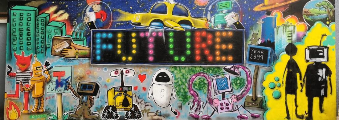 Das Bild zeigt ein Foto von einer Graffitiwand. In der Mitte des Graffitis steht groß Future. Im Hinergrund sind Hochhäuser, Planeten und ein fliegendes Auto. Im Vordergrund sind verschiedene Roboter zu sehen. 