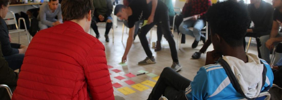 Stuhlkreis bei einer Workshop-Methode, jemand legt etwas in der Mitte ab