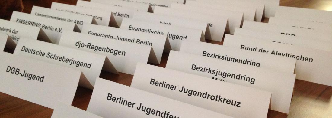 Nahaufnahme von 34 vorbereiteten Tischkärtchen mit den Namen von Berliner Jugendverbänden