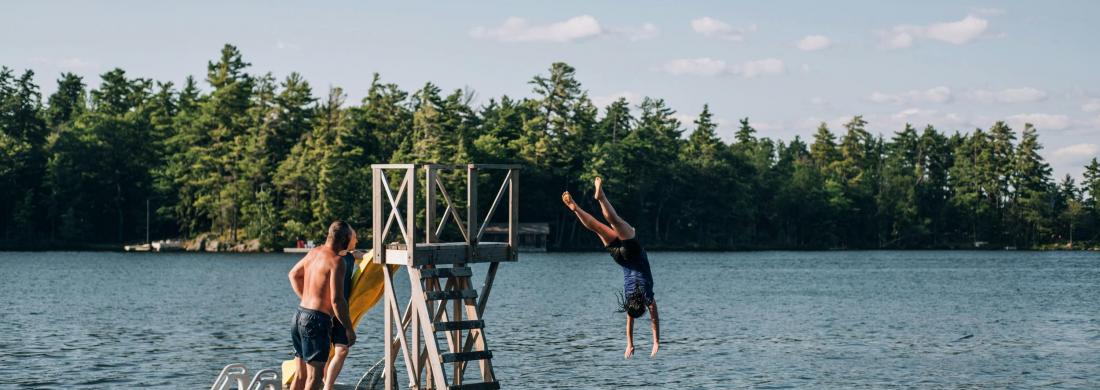 Jugendliche springen von einem Floß in den See
