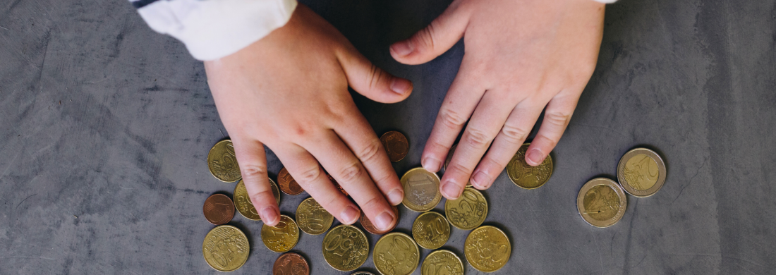 Kinderhände zählen Münzen auf einem Tisch