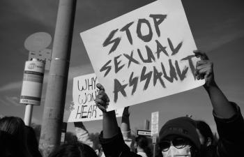 Auf einem Demo-Schild steht: "Stop sexual assault" (deutsch: "sexuelle Übergriffe stoppen")