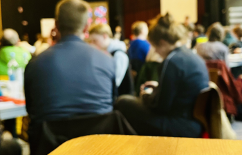 Delegierte bei der Mitgliederversammlung sitzen an Tischen