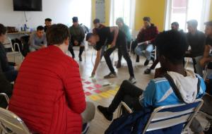 Stuhlkreis bei einer Workshop-Methode, jemand legt etwas in der Mitte ab