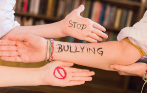 Drei Arme mit Aufschrift Stop Bullying gegen Gewalt und Mobbing an Schulen