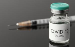 Ein Fläschchen mit COVID19-Impfstoff steht vor einer Spritze