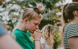 Junge Frau mit geschlossen Augen wirkt nachdenklich – Symbol für Unsicherheit und Belastung.
