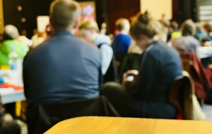 Delegierte bei der Mitgliederversammlung sitzen an Tischen